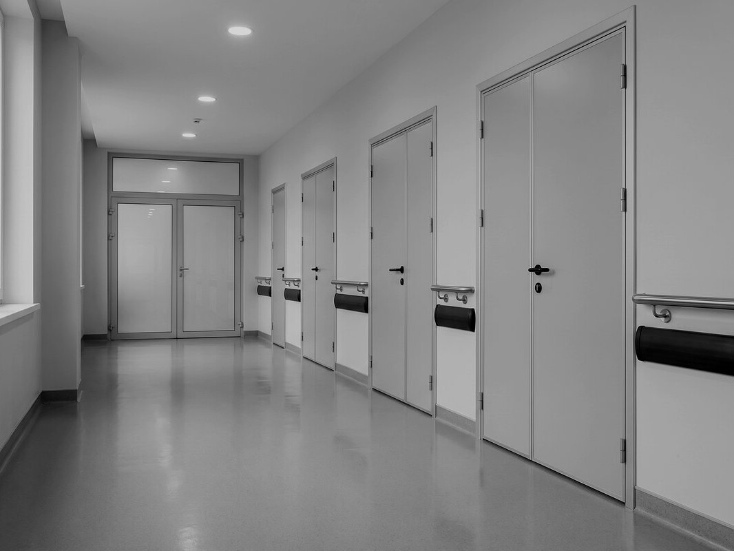 Corridoio di reparto ospedaliero con porte delle degenze in alluminio